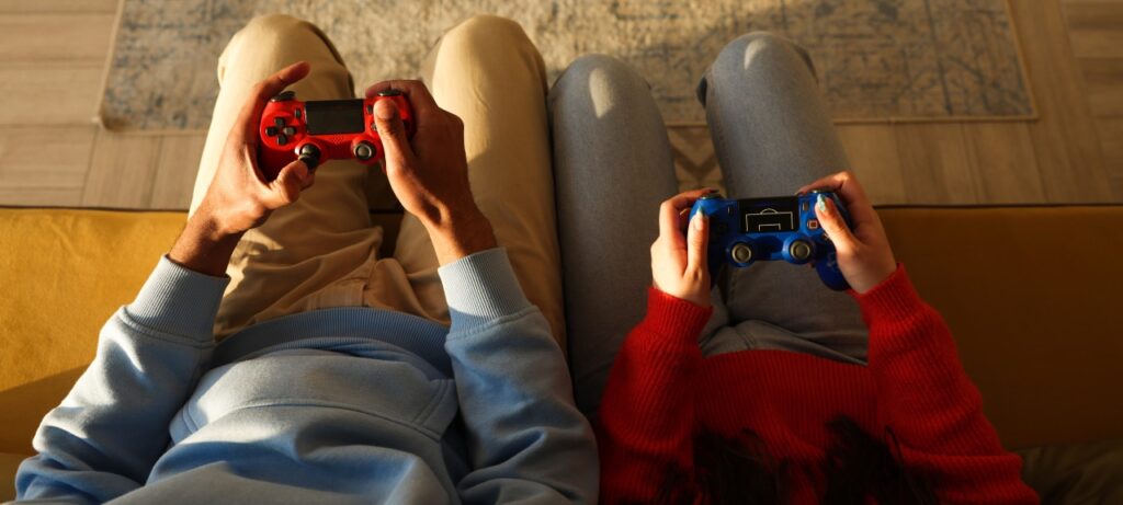 Deux personnes vues de haut avec une manette de jeux vidéo dans les mains